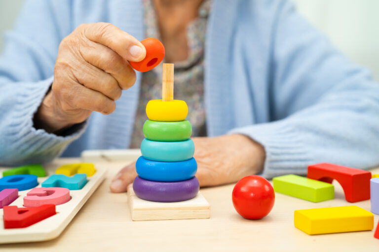 Ältere Person spielt mit Bauklötzen.