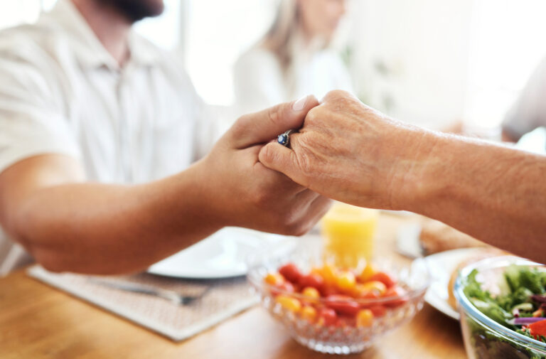 Hände halten sich über einem Tisch