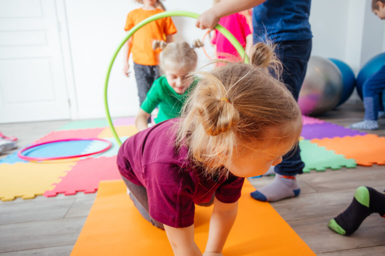 Kinder spielen mit Hula-Hoops.